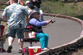 woman in chair fishes from jetty