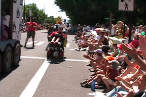chuck in wheelchair in parade with giant float